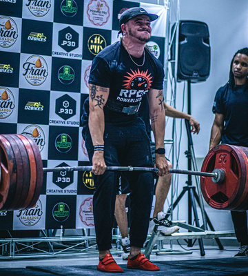 Atleta executando levantamento terra em competição de powerlifting