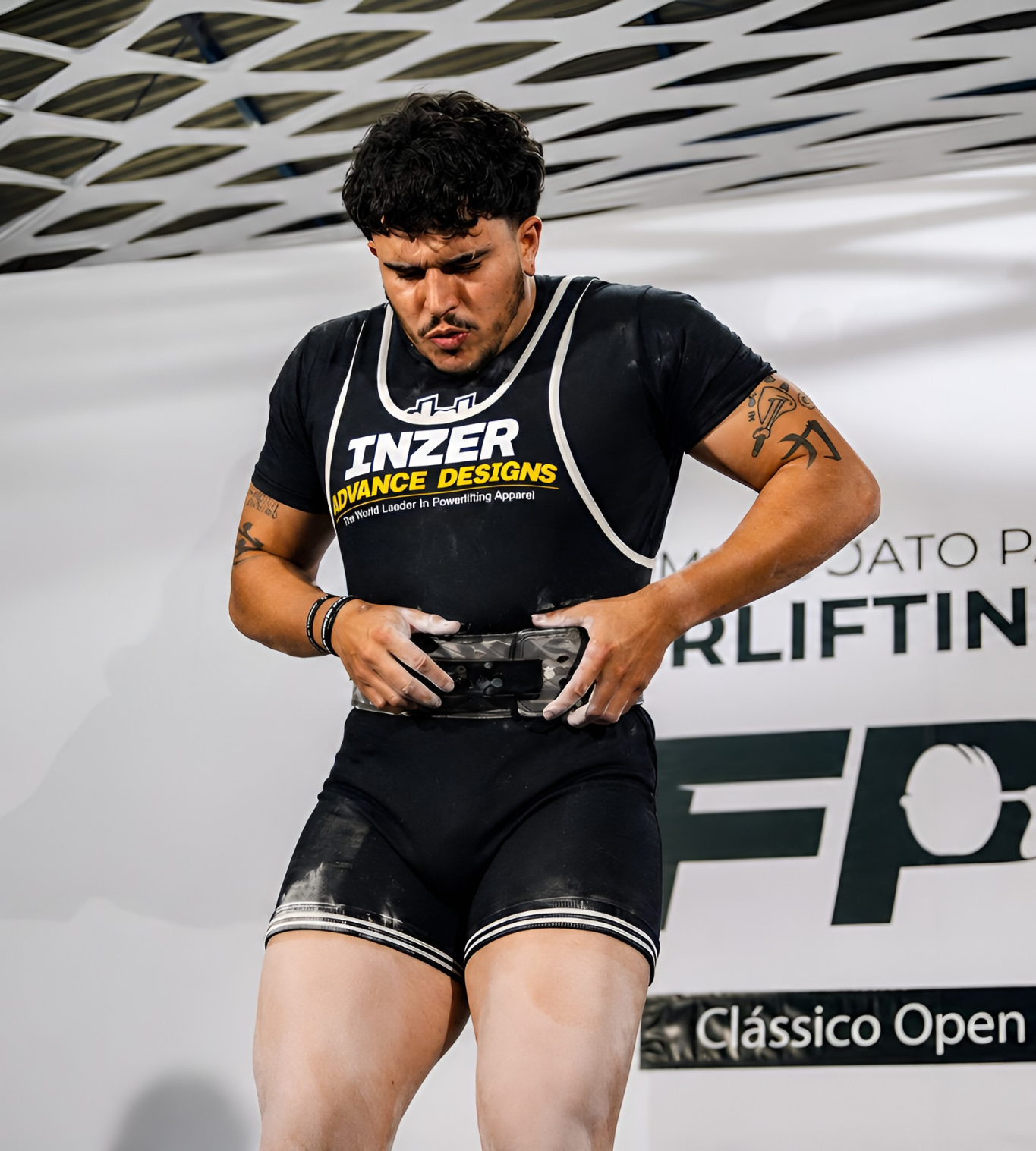 Atleta ajustando o cinto antes de uma tentativa em competição de powerlifting