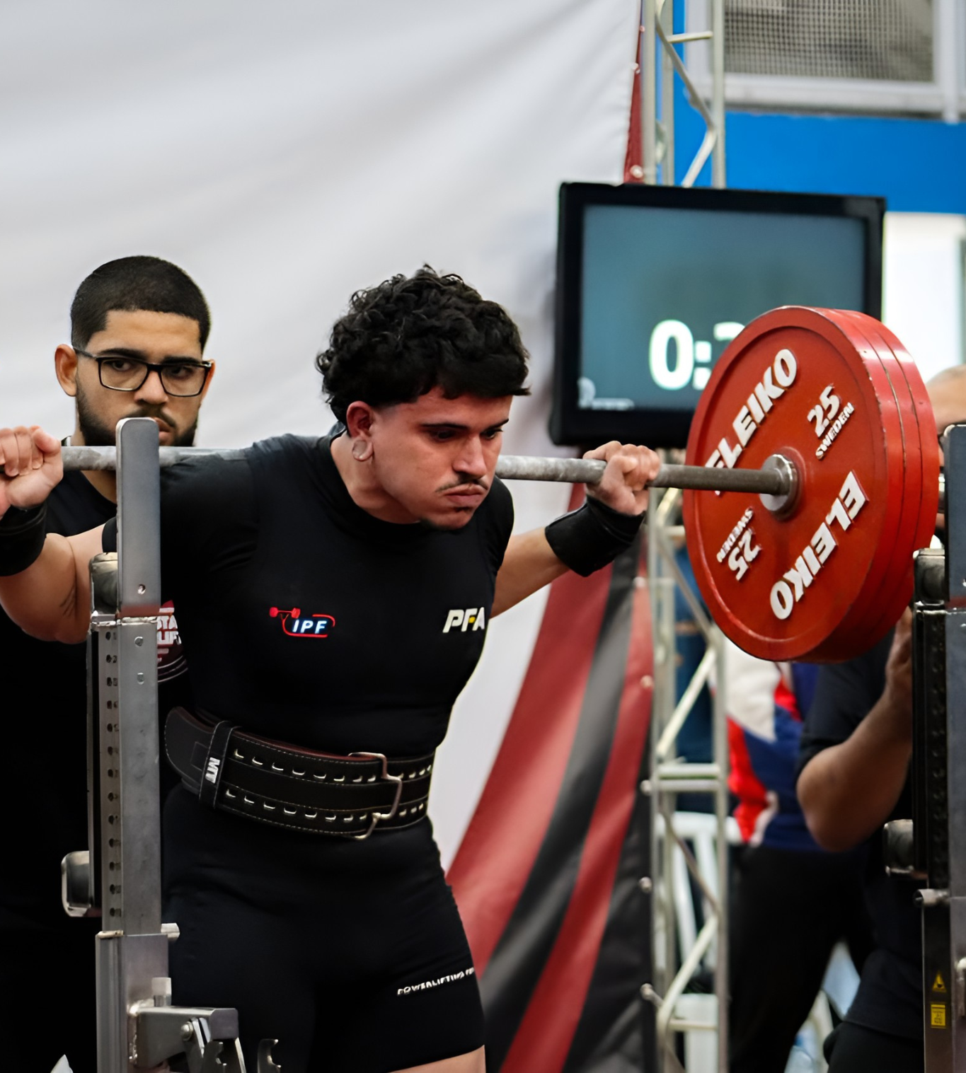 Atleta posicionado para o agachamento em competição de powerlifting